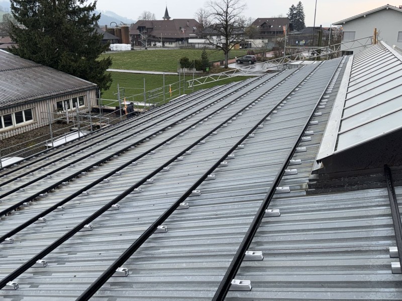 Metal roof with aligned solar mounting rails and brackets, ready for panels